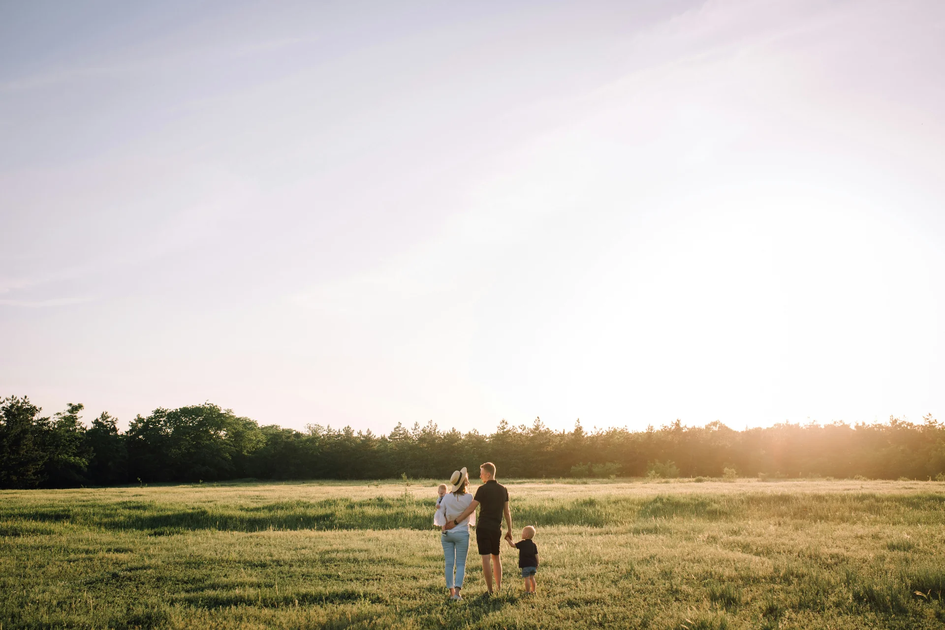 Familia caminando por un campo al atardecer